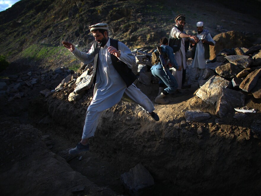 Afghan National Army soldiers search a group of men near the village of Kasan.
