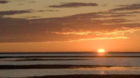 A sunset over a watery lanscape