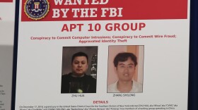 A poster displayed during a news conference at the Department of Justice in Washington, Thursday, Dec. 20, 2018, shows two Chinese citizens suspected to be with the group APT 10 carrying out an extensive hacking campaign to steal data from U.S. companies. (Manuel Balce Ceneta/AP)