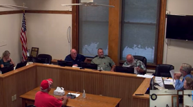 A room filled with people speaking to a podium.