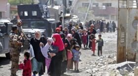 Iraqis leave the Zanjili neighbourhood in west Mosul on June 3, 2017, during the ongoing offensive by security forces to retake the city from Islamic State group fighters. (Karim Sahib/AFP/Getty Images)