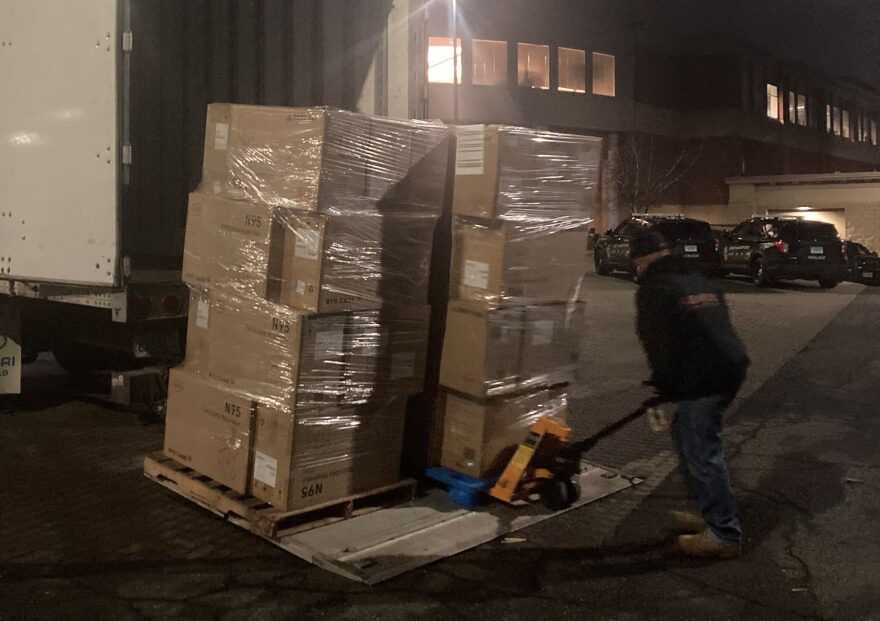 A worker unloads a pallet of N95 masks in East Hartford on Thursday evening. The masks were brought from a warehouse in New Britain.