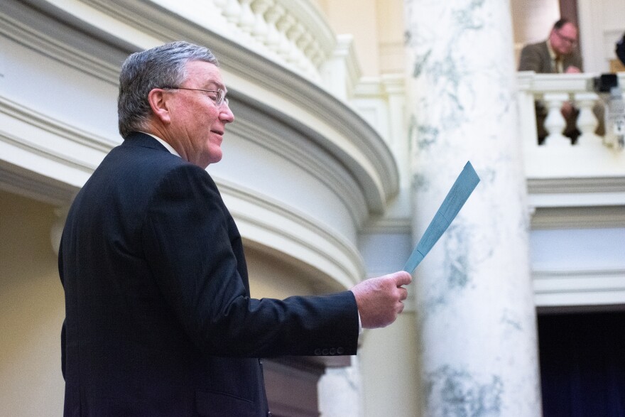 House Speaker Scott Bedke stands holding a paper in the state capitol