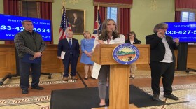 Ohio Department of Health Director Dr. Amy Acton speaks at a news conference, as Lt. Gov. Jon Husted, Gov. Mike DeWIne and First Lady Fran Dewine and Commerce Director Sherry Maxfield look on. A sign language interpreter is present at these events. 