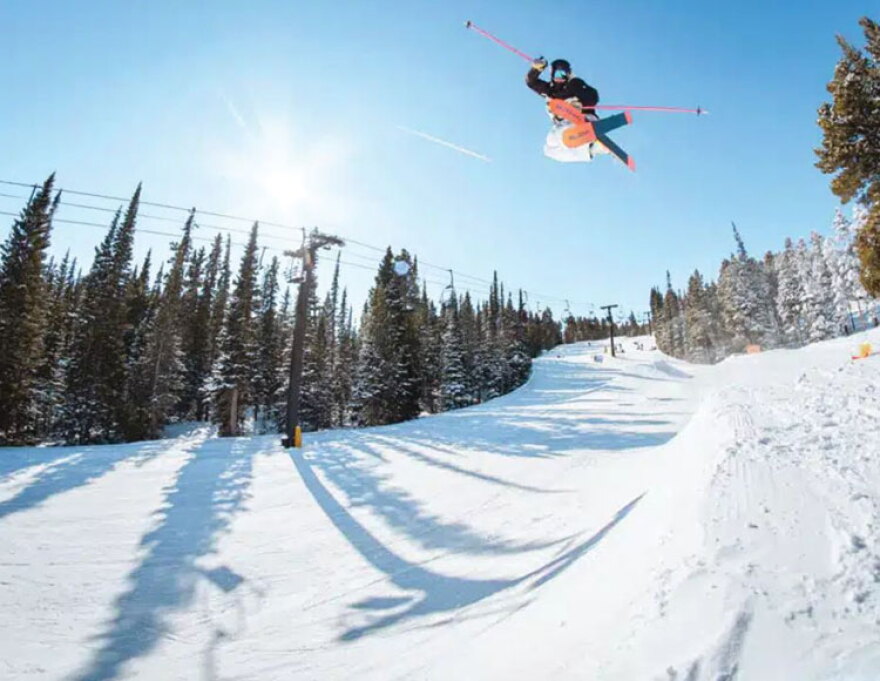 A skier jumps high up into the air going down a snowy run at the Eldora Mountain Ski Resort in Boulder County.