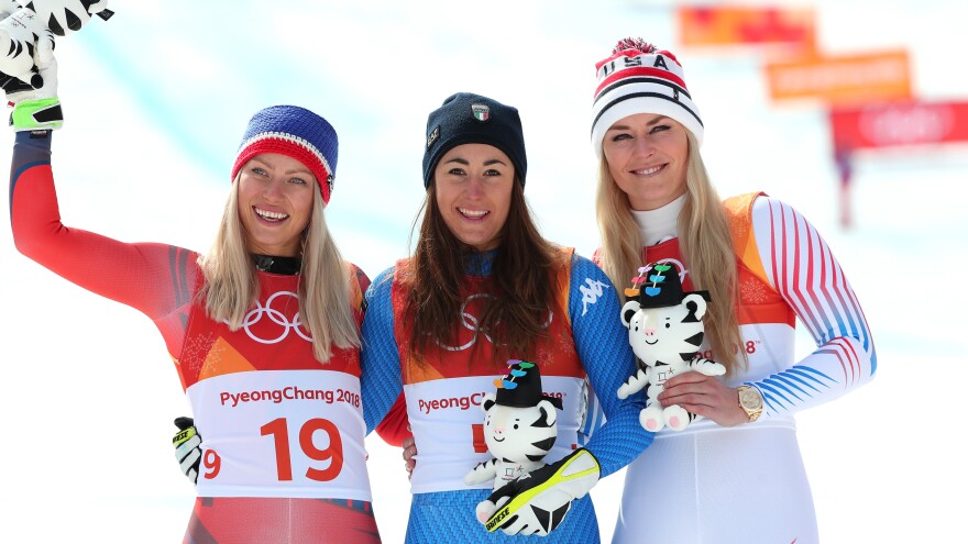 Bronze medalist Lindsey Vonn, right, celebrates on the podium with gold medalist Sofia Goggia of Italy, center, and silver medalist Ragnhild Mowinckel of Norway, after the women's downhill in the Pyeongchang Winter Olympics.