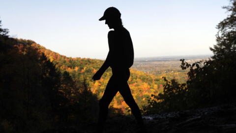 A hiker takes in the fall colors as she makes her way along the Indian Ladder Trail at John Boyd Thacher State Park on Tuesday, Oct. 18, 2016, in Voorheesville, N.Y. (Mike Groll/AP)