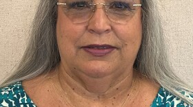 Woman with long grey hair and glasses