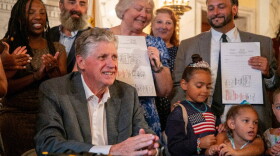 Gov. Dan McKee signed legislation expanding Rhode Island’s Temporary Caregiver Insurance program during a State House ceremony on Aug. 20, 2025. To the right of McKee are Senate President Valarie Lawson and Rep. Joshua Giraldo, who sponsored the legislation in their respective chambers.