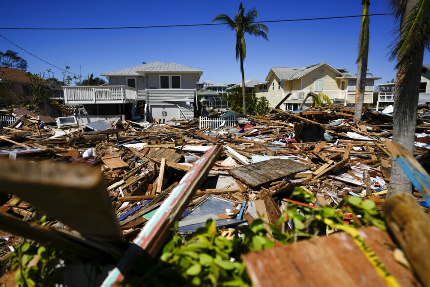 A road is completely filled with a tall pile of debris from destroyed beachfront homes and businesses, two days after the passage of Hurricane Ian, in Fort Myers Beach.