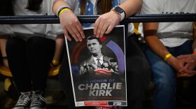 An attendee holds a poster of Charlie Kirk at a Turning Point USA rally at Utah State University, as a part of the organization's push to memorialize Kirk, Tuesday, Sept. 30, 2025, in Logan, Utah.
