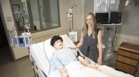 WSU Spokane College of Nursing assistant dean for research Lois James poses beside the lab mannequin that tired nurses interacted with in a recent study.