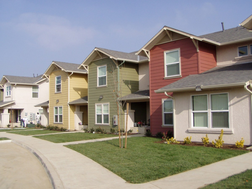 Image of the outside of a row of houses in a neighborhood.