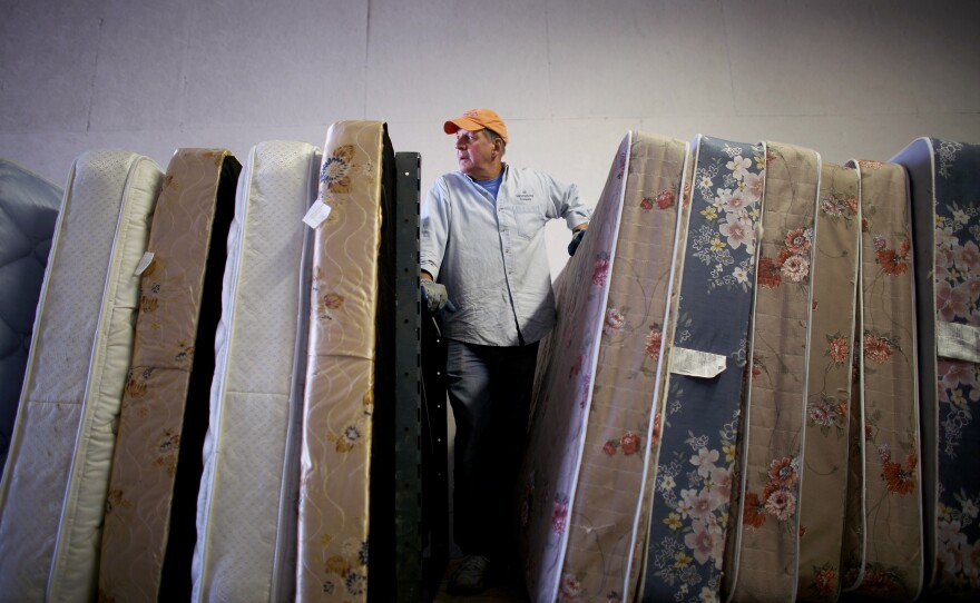 Volunteers from Epworth Furniture Ministry prepare donated mattresses for distribution in Perrysburg, Ohio. A tight-knit group of volunteers and assistance agencies in the Toledo area help incoming refugees and local families in need.