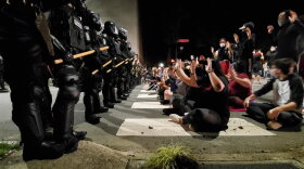 Protesters seated in front of officers at Hillsborough and Salisbury in downtown Raleigh on Sunday night.