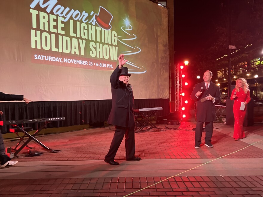 Flanked by emcees from official sponsor KY3, Springfield Mayor Ken McClure greets a crowd of hundreds of families at the Springfield Mayor's Tree Lighting and Holiday Show on November 23, 2024.