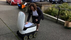 State Rep. Shelley Kloba puts proposed delivery robot regulations in a Starship Technologies delivery robot to carry to the House Transportation Committee chair.
