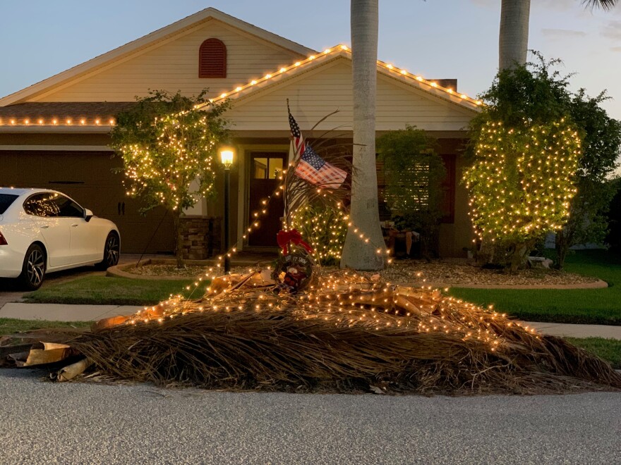 The debris pile is lit with white lights for Christmas, just like two smaller trees in the front yard.