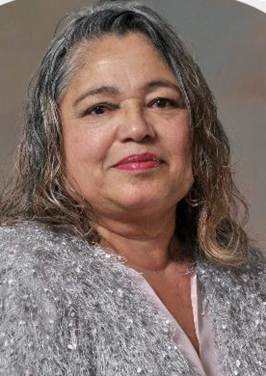 A woman wearing a silver top.