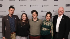 Five people stand side-by-side.