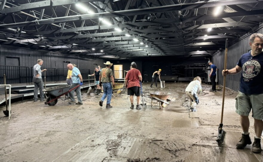 volunteers shovel out mud in the black box theater