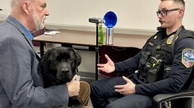 Fred Sauceman interviews Sergeant Tim Hensley, as K9 Buck sits on Fred's lap.