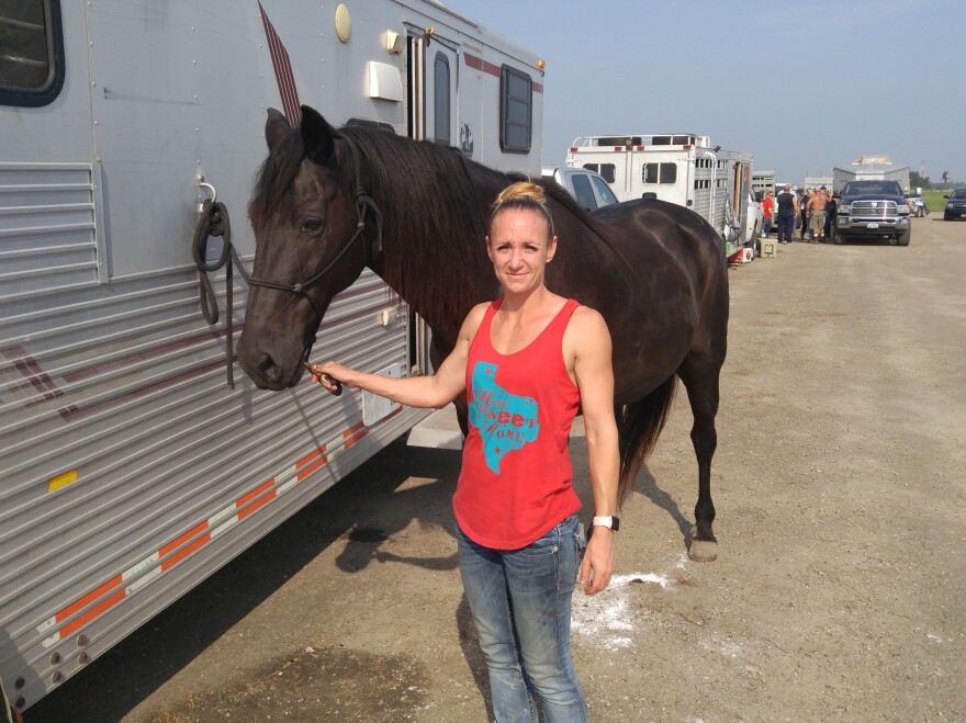 Amy Walters from Copperas Cove, Texas, with a horse she rode as she rounded up lost cattle and brought them to the makeshift shelter in Beaumont, Texas.