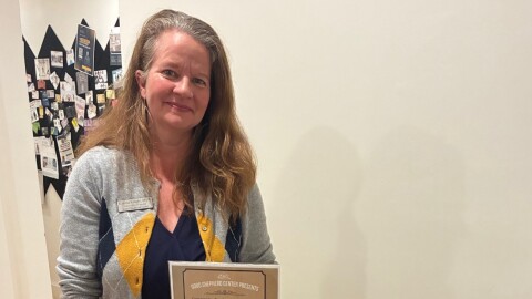 Good Shepherd Center Executive Director Katrina Knight poses with the book her organization is focused on this month: There is No Place For Us: Working and Homeless in America.