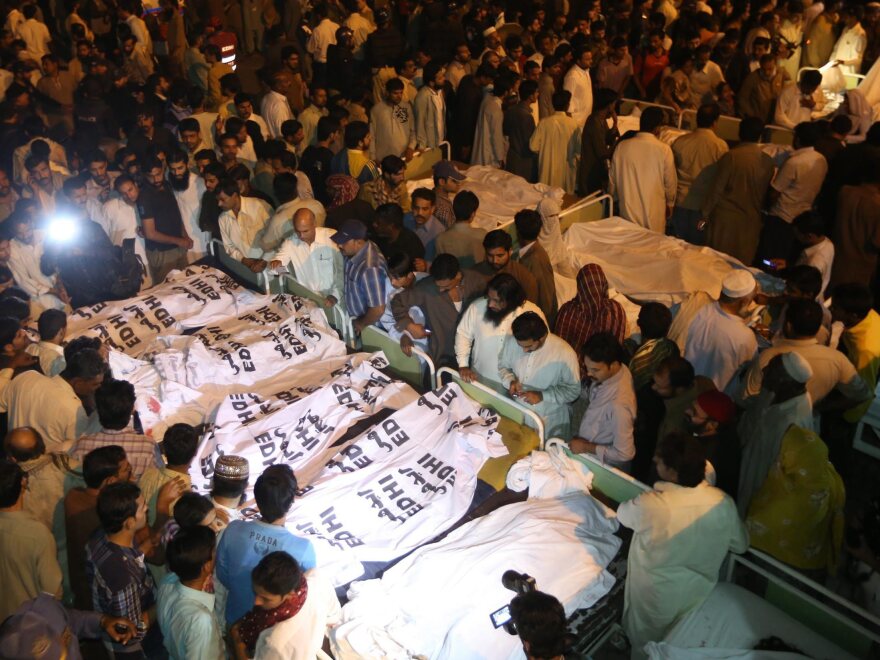 Locals crowd around the bodies of victims from a suicide bomb attack, at a hospital in Lahore on Sunday.