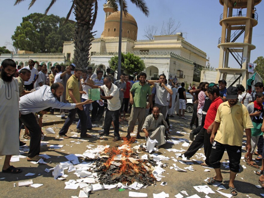 Rebel supporters burn books on the philosophy of Gadhafi in Tripoli on Saturday.  Libyan rebel leaders say they're negotiating with regime loyalists in holdout towns.