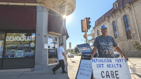 Dominic Vittone of Janesville holds a sign decrying Republican cuts to health care on the sidewalk outside the Rock County Democrats’ office in downtown Janesville from September of this year. Early voter data suggests southern Wisconsin could be a battleground area in deciding many races in the state. Midterm Election day is Tuesday, November 3.