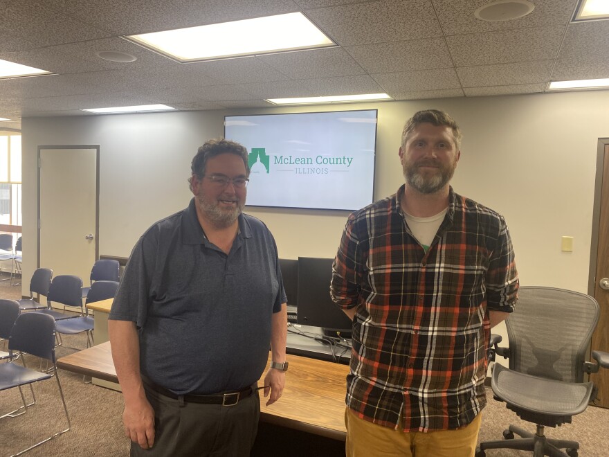 Craig Nelson and Dan Leary stand beside each other inside the Downtown Bloomington Government Center.