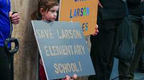 A child holds a "Save Laarson Elementary School" sigh at the Matanuska-Susitna School District School Board meeting in Palmer March 4, 2026.