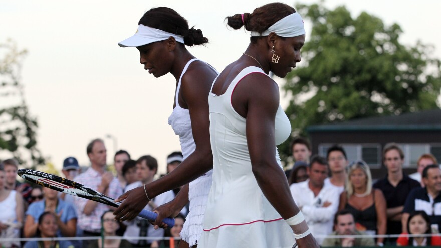 Serena Williams (left) and her sister Venus Williams in action during their first-round doubles match on Day 2 at Wimbledon in 2010.