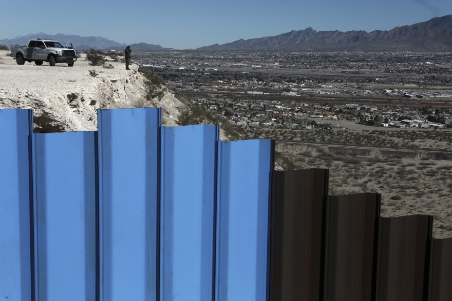 In this Jan. 25, 2017, file photo, an agent from the border patrol, observes near the Mexico-US border fence, on the Mexican side, separating the towns of Anapra, Mexico and Sunland Park, N.M. 