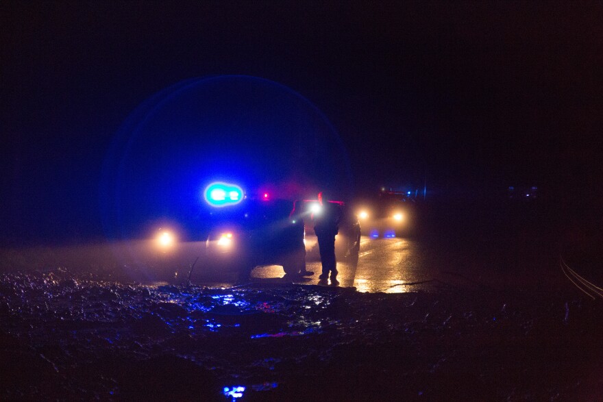 State police stand behind a massive mudslide on route 39 near Richwood. Mudslides isolated the town for most of the night Thursday.