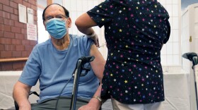 A nursing home resident receives a COVID-19 booster shot.