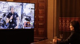 A woman on a TV screen and another woman sitting at a desk 