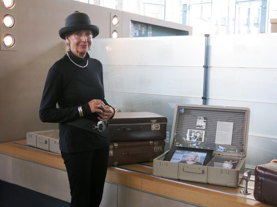 Neff stands next to the museum exhibit about her escape. It includes silverware and a porcelain figure, among the few valuables she and her mother were able to take with them.