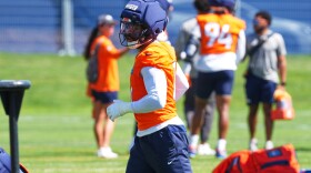 Denver Broncos linebacker Jonathon Cooper wears an orange jersey and blue helmet.