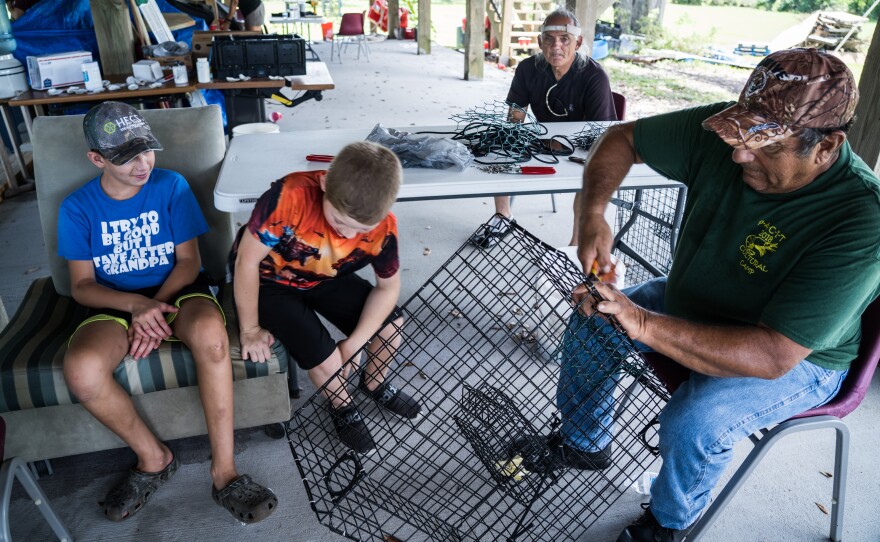 Earl Billiot helps campers construct crab traps for them to take home and use on the bayou.