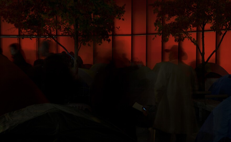 People are shown as they walk around set up tents during a rally to protest sweeps of homeless camps on Wednesday, November 1, 2017, outside of City Hall in Seattle.