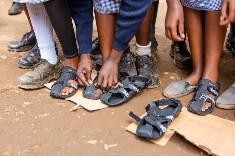 Kids try on new shoes from Because International.