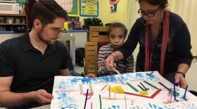 Donald Welch, left, helps a student at Brucie Ball Educational Center create poetry.