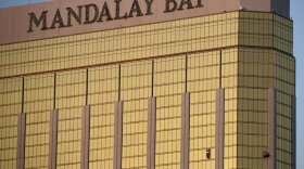 On Oct. 2, 2017, drapes billow out of broken windows at the Mandalay Bay resort on the Las Vegas Strip, following a deadly shooting at a music festival. On Tuesday, the company that owns the hotel offered to make a $500 charitable donation for victims who authorize their lawyers to accept legal notice of the company's lawsuit. CREDIT: JOHN LOCHER
