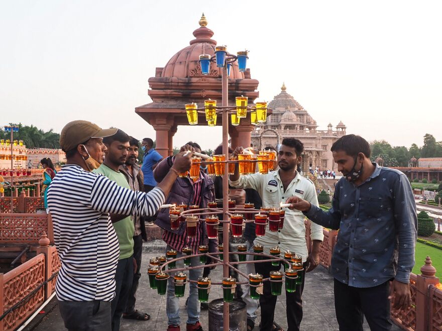 People light oil earthen lamps on the eve of Diwali at the Akshardham Hindu temple in Gandhinagar, India, on Wednesday.