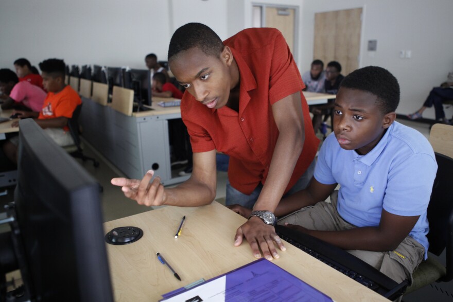 Darryl Burrell, a junior at Morgan State, helps rising seventh-grader Antonne Richardson, 11, build his 3-D ruler.