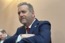 Attorney General Dave Yost leans on a banister in the Ohio House chamber in March 2025 ahead of the State of the State.
