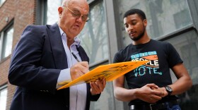 Kurt Kloss, 63, of Webster Groves, signs a Missourians for Constitutional Freedom-led ballot petition in an attempt to legalize abortion in Missouri, alongside volunteer Stephen Wilder, 24, on Monday, April 1, 2024, in downtown St. Louis.