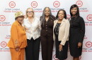 Four women standing in front of a Urban League of Florida Suncoast banner smiling 